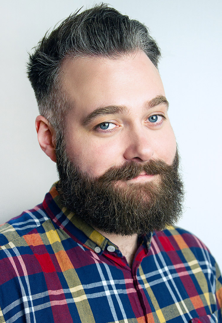 A man with a full dark beard in a brightly checked shirt