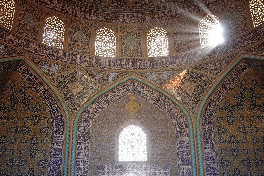 The inside of a tiled dome, light falling through its windows